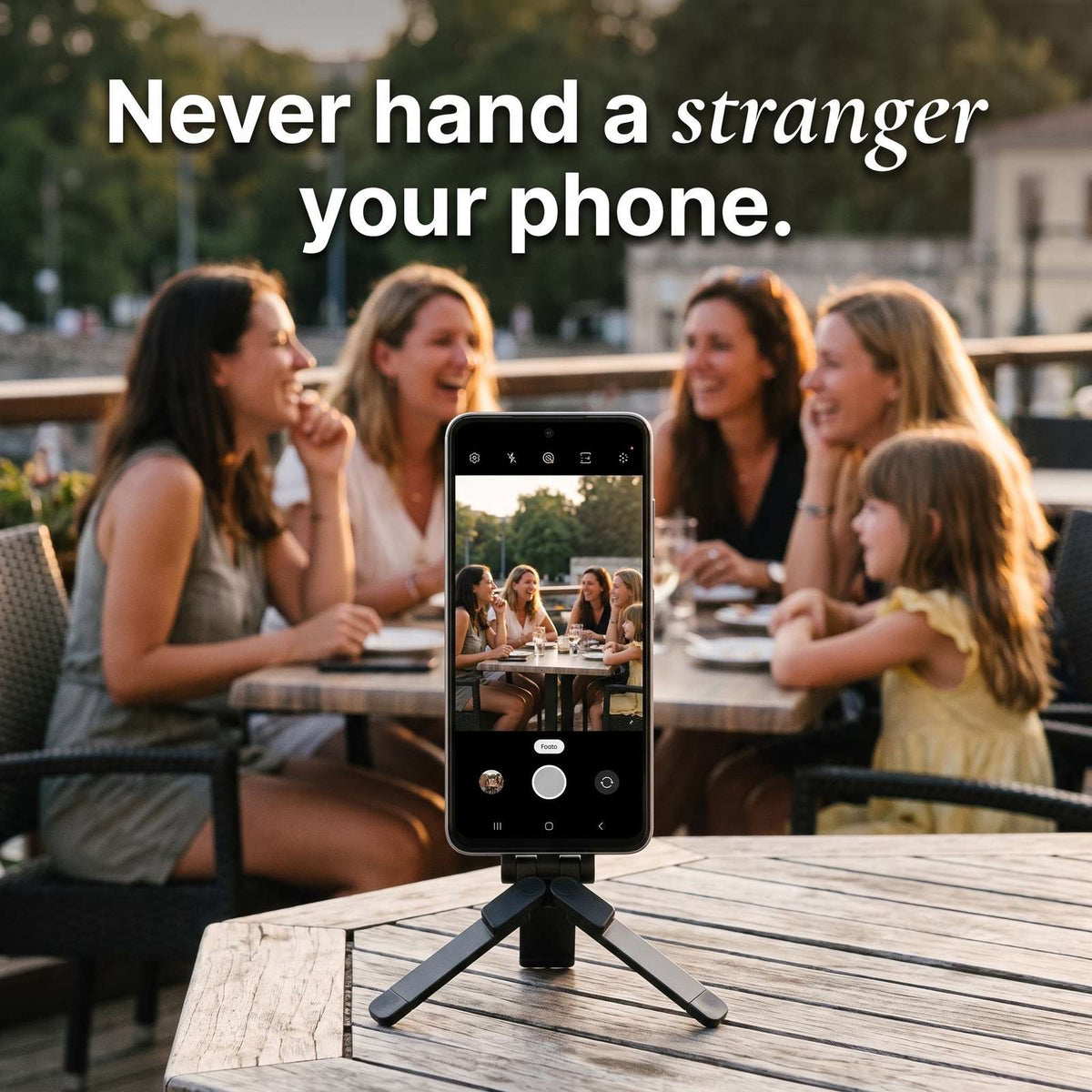 Never hand a stranger your phone: Pose holding a phone on a terrace table while a group poses together